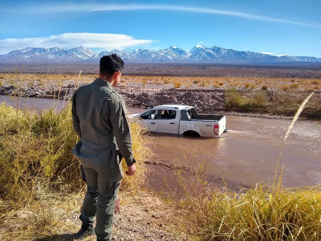 Personal de Gendarmería observando el vehículo encallado. 