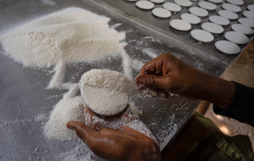 El productor de casabe Eriel Núnez da forma de tortilla al casabe con un molde de forma redonda, en Quivicán, Cuba, el lunes 28 de mayo de 2023. Casabe, una tortilla hecha de yuca, también conocida como cassava, es uno de los alimentos de origen indígena más antiguos de Cuba. (AP Foto/Ramón Espinosa)