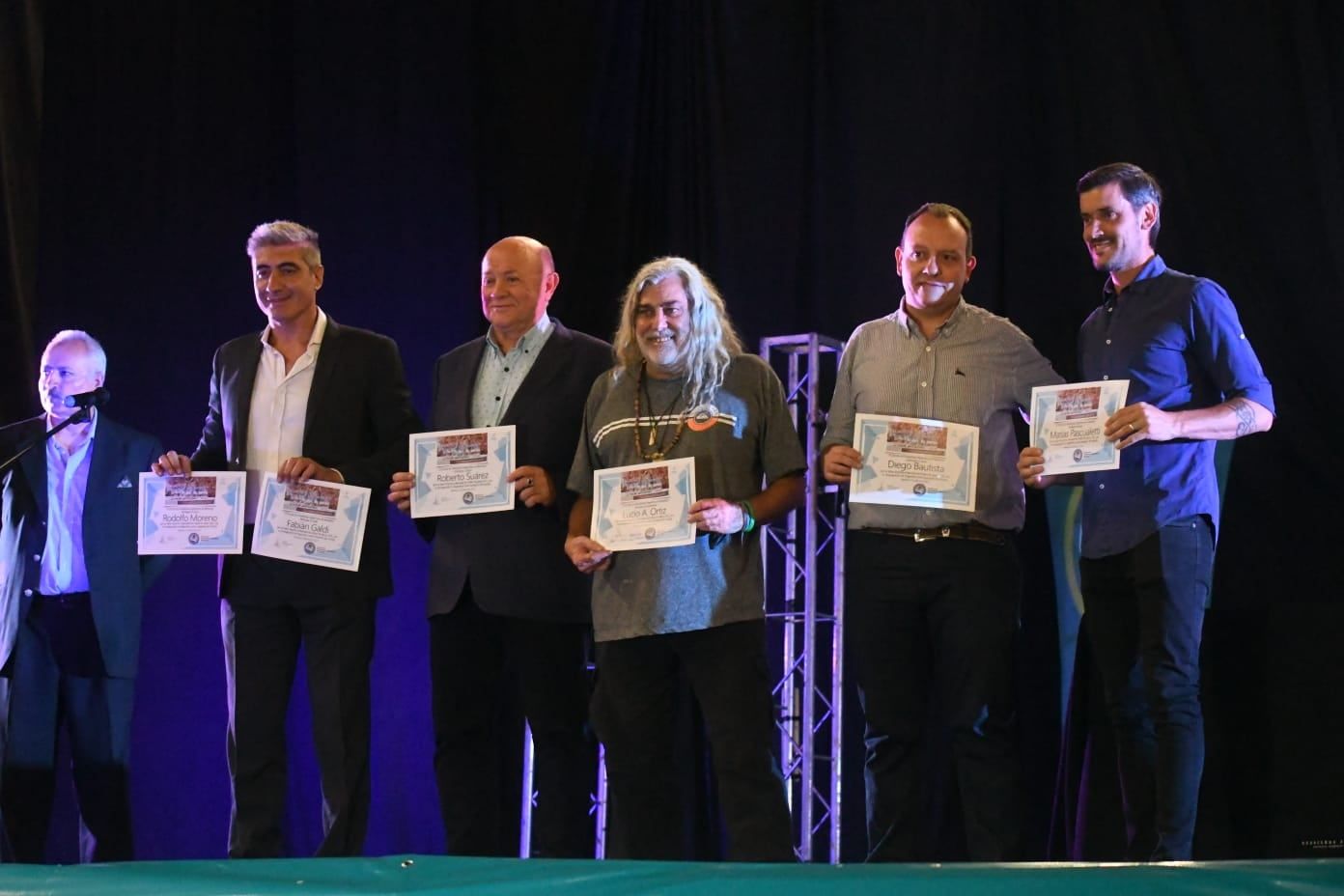 Emilio Medina (uno de los conductores de la noche) sostiene los diplomas de Rodolfo Moreno y Fabián Galdi. En la foto, Roberto Suárez, Lucio Ortíz, Diego Bautista y Matías Pascualetti, periodistas mendocinos presentes en Qatar 2022, cuando la Selección Argentina gritó campeón del Mundo. / José Gutiérrez (Los Andes).