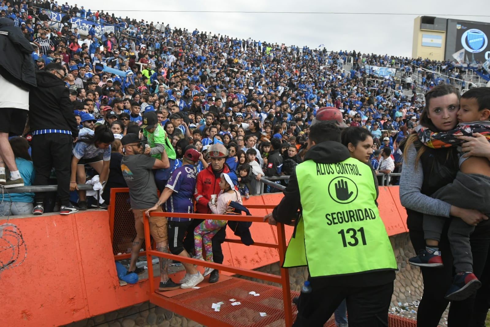 Los hinchas de Godoy Cruz le escapan al gas pimienta que tiró la pelicía en las afueras del estadio para dispersar a la barra / José Gutiérrez.