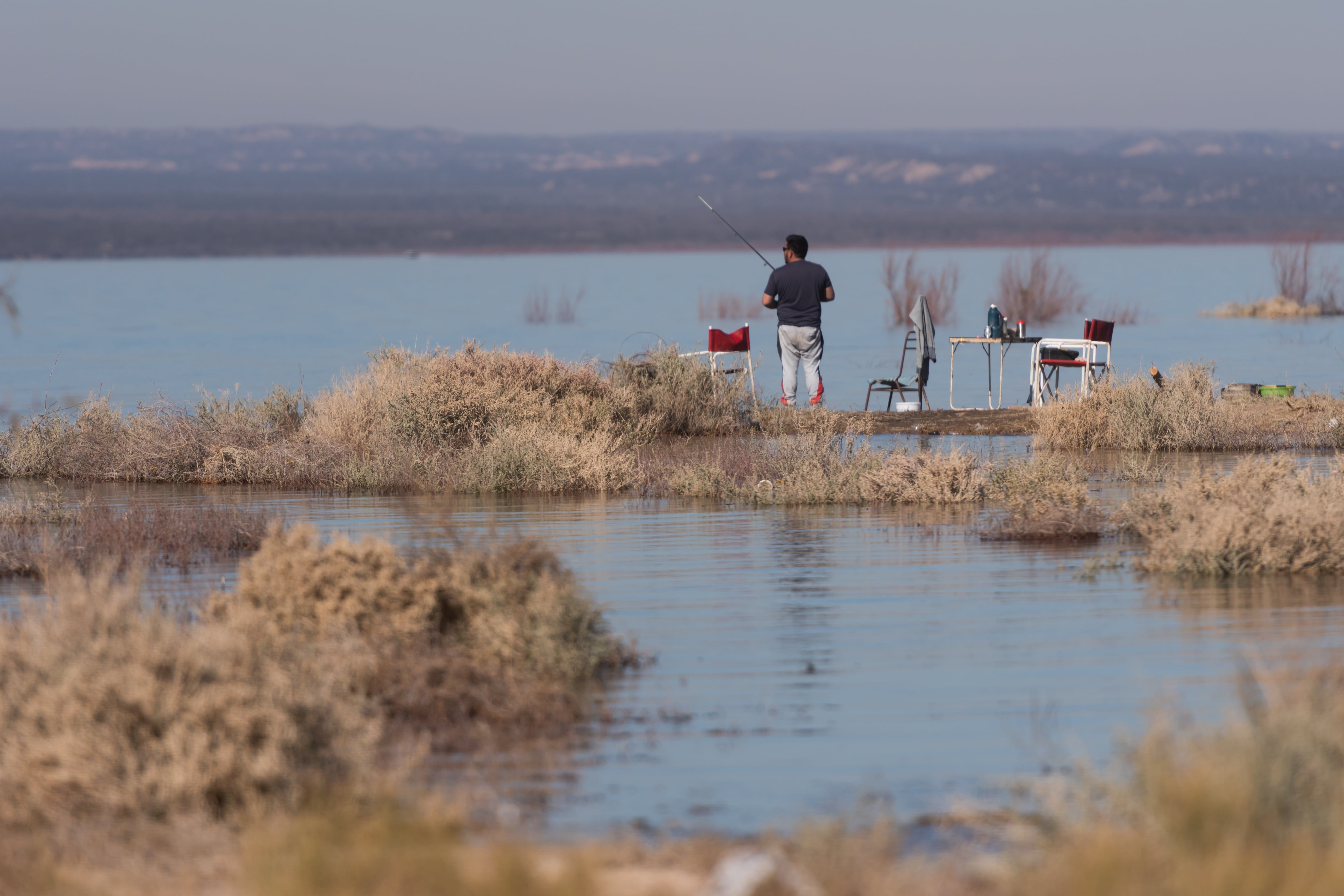 Un hombre pesca en una orilla de un camping del dique El Carrizal.

Foto: Ignacio Blanco / Los Andes


