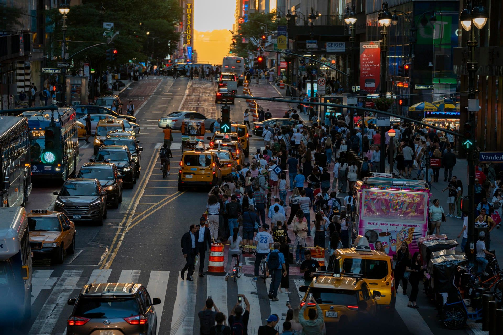 AME9717. NUEVA YORK (ESTADOS UNIDOS), 28/05/2024.- Cientos de turistas esperan para ver el Manhattanhenge, fenómeno que se produce dos veces al año en torno al solsticio de verano cuando el sol desciende en una vertical perfecta entre los rascacielos, este martes en Manhattan, Nueva York (EE. UU). El fenómeno atrae a cientos de turistas para capturar ese momento único en que el sol se esconde justo en la base entre dos rascacielos en algunas de las avenidas más emblemáticas de Manhattan. EFE/ Ángel Colmenares
