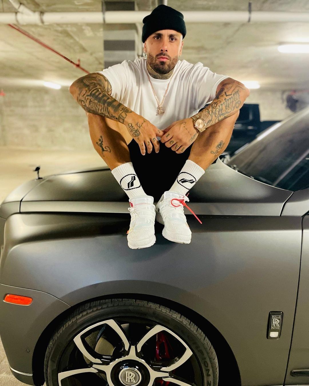 Los pies encima del capot de su Rolls Royce