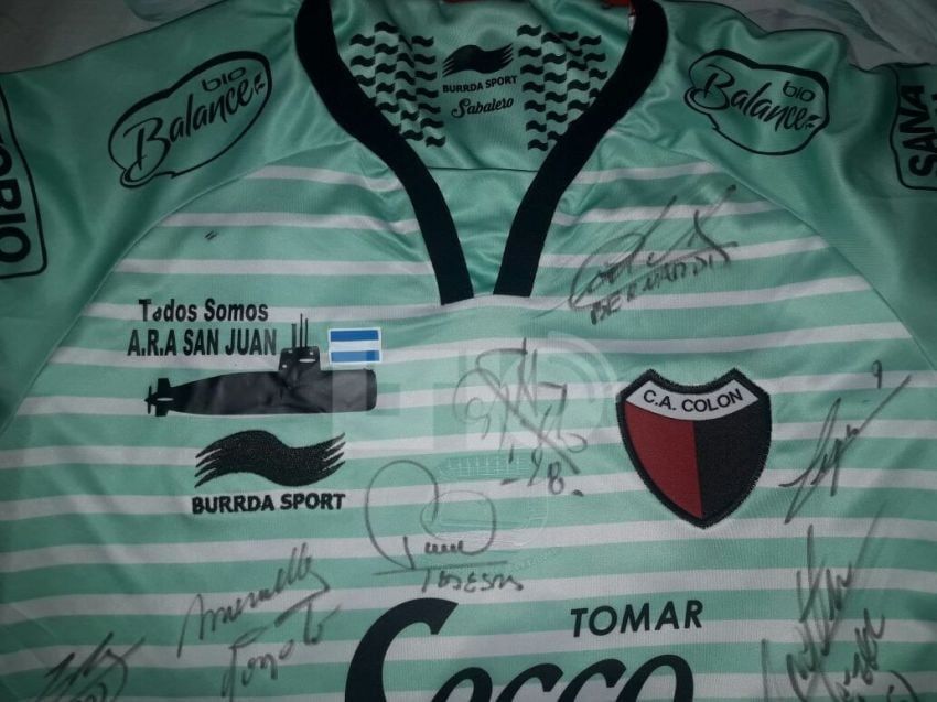 
    La camiseta de Colón autografiada para Damián Espinosa, tripulante del submarino. Foto: Gentileza LT10
   