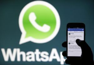 A Whatsapp App logo is seen behind a Samsung Galaxy S4 phone that is logged on to Facebook in the central Bosnian town of Zenica, February 20, 2014. Facebook Inc will buy fast-growing mobile-messaging startup WhatsApp for $19 billion in cash and stock in