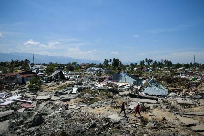 Dos rescatistas caminan entre el desastre que dejó el terremoto. / AFP