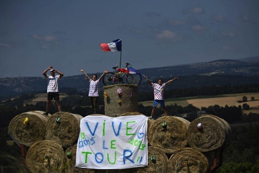 
Foto: AFP | Fanáticos del ciclismo saltan y alientan a los corredores con una bandera que dice "Viva el Tour".
   