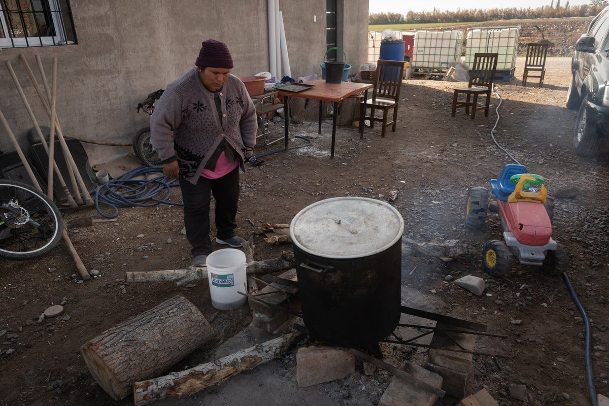 Yolanda Amador calienta agua para preparar el almuerzo en su nueva vivienda en Las Violetas (Lavalle). Foto: Ignacio Blanco / Los Andes