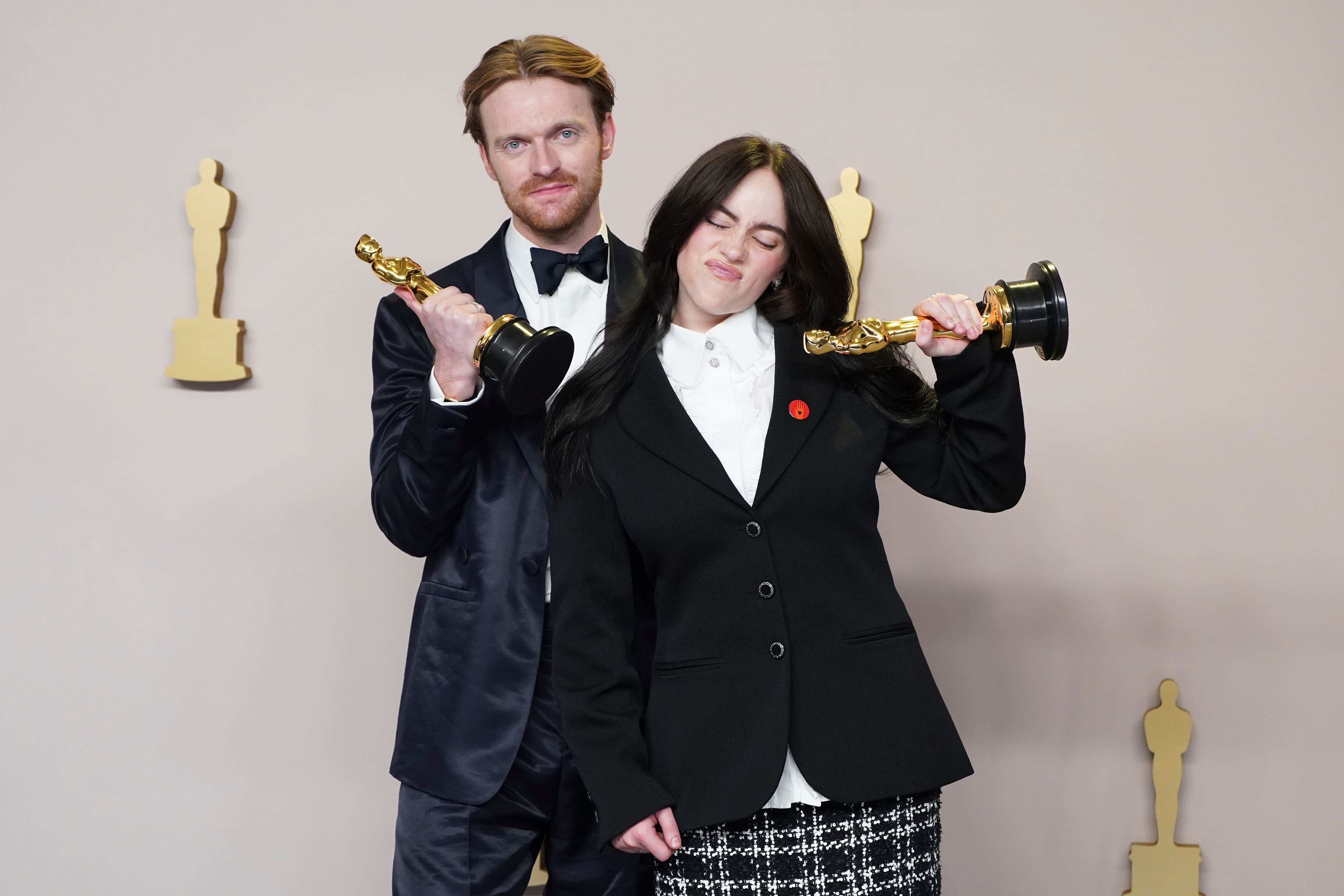 Finneas O'Connell y Billie Eilish posan en la sala de prensa con su Oscar por mejor canción original por 