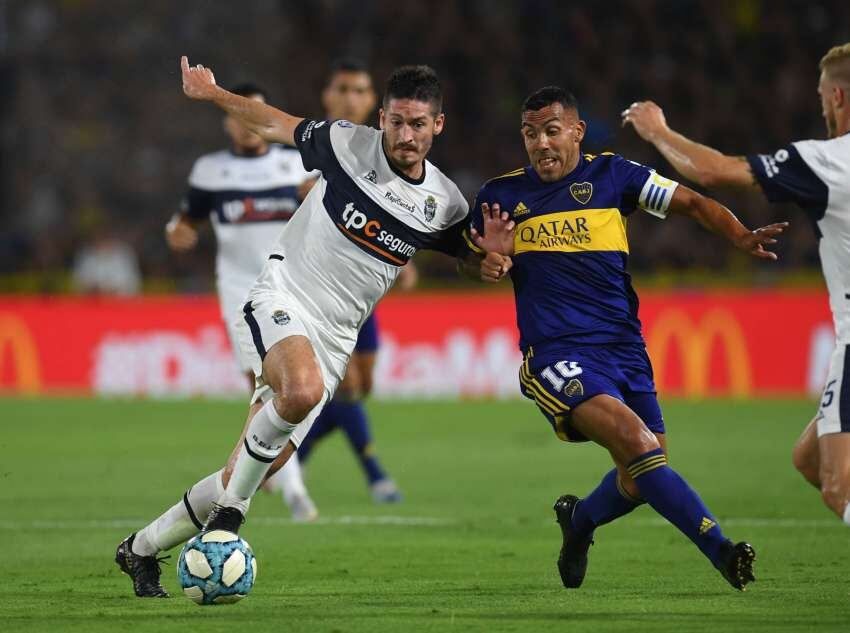 
    Tevez lucha por escapar de la marca rival. / Télam
   