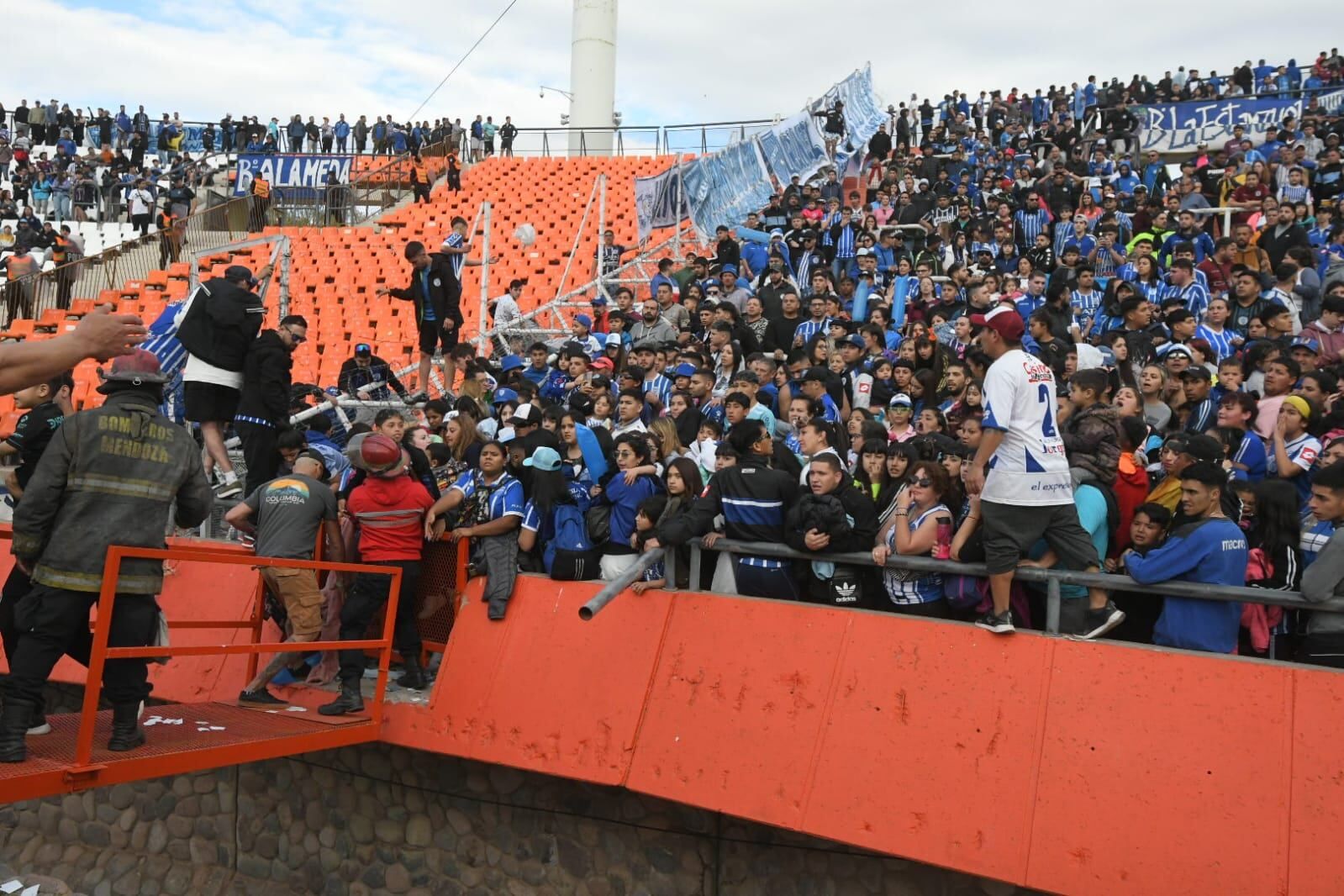 Los hinchas de Godoy Cruz le escapan al gas pimienta que tiró la pelicía en las afueras del estadio para dispersar a la barra / José Gutiérrez.