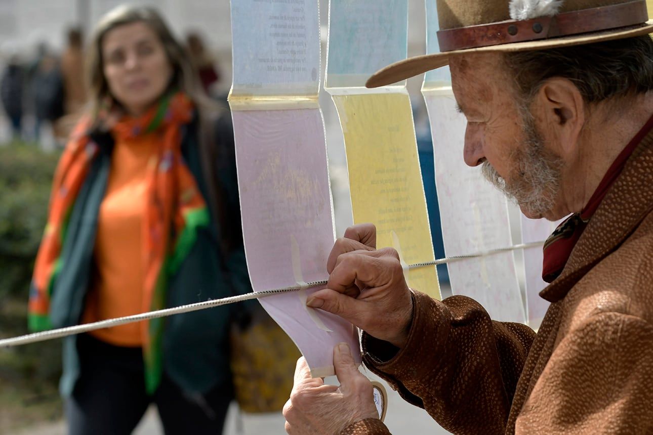 Santos pegando sus obras por detrás, para evitar que a las palabras se las lleve el viento .Foto: Orlando Pelichotti 
