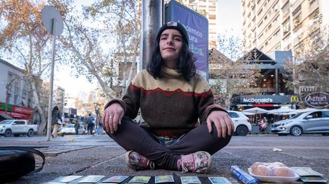 Los Andes | Instalada en un rincón de la vereda Oeste y sólo con un mantel y sus cartas, Vicky llama la atención de quienes pasan por la transitada esquina de San Martín y Espejo. | Foto: Ignacio Blanco / Los Andes