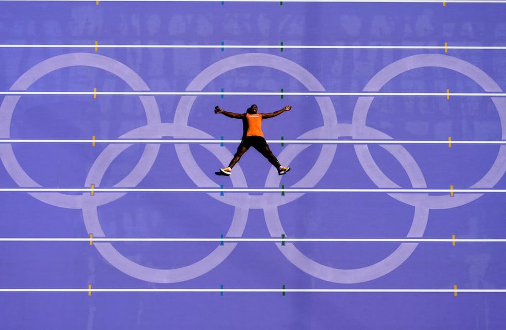 Un atleta holandés se recuesta en la pista tras una práctica en los Juegos Olímpicos de París, el jueves 1 de agosto de 2024 en Saint-Denis (AP Foto/David J. Phillip)