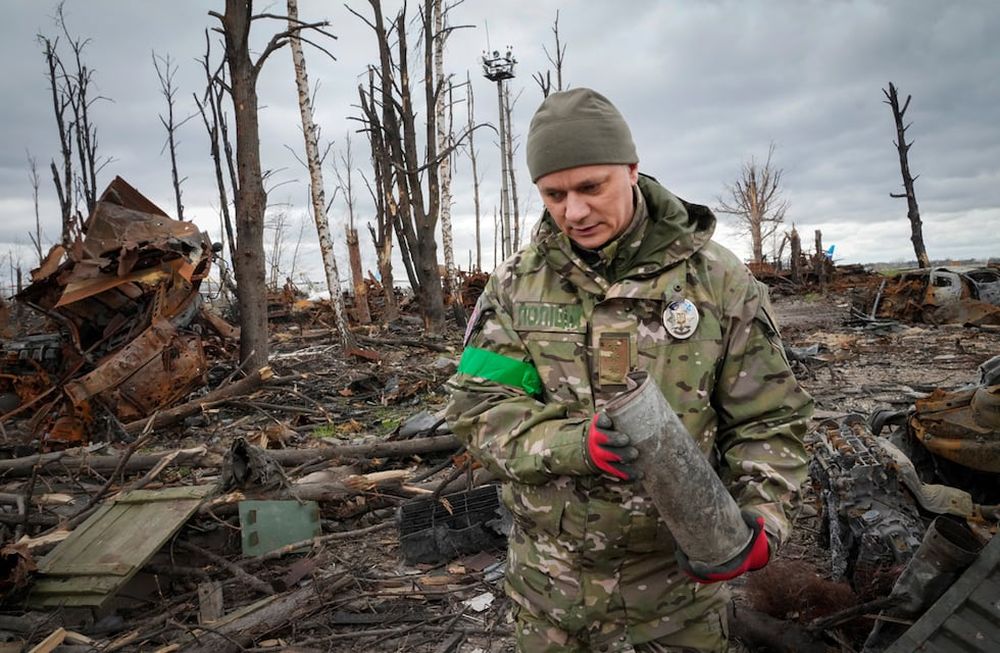 Un militar del Ministerio del Interior recoge proyectiles sin explotar, granadas, minas, después de las recientes batallas en Hostomel cerca de Kiev. (AP/Efrem Lukatsky)