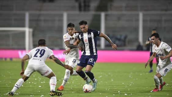 Enzo Díaz con la pelota, rodeado de jugadores visitantes, en el duelo entre Talleres e Independiente, en el Kempes, por el cierre de la Liga Profesional. (Foto: Ramiro Pereyra / La Voz)