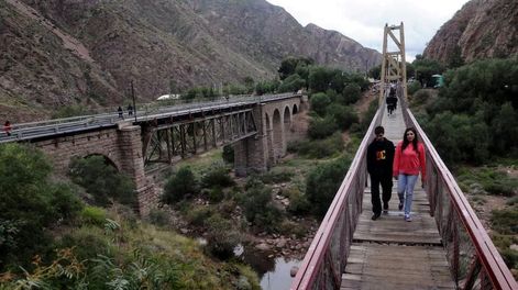 Una postal de Cacheuta. El famoso puente colgante junto al ferroviario. La oferta gastronómica del lugar ha ido creciendo.