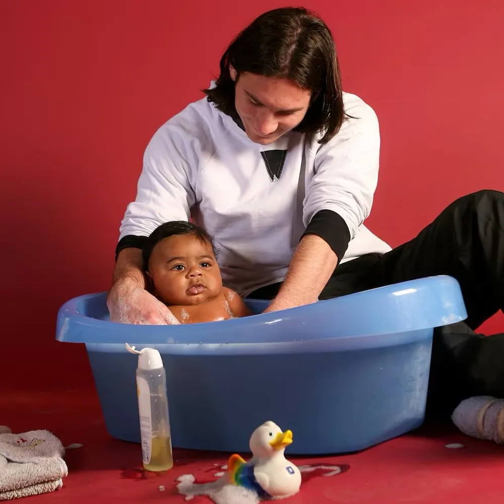 Un joven Lionel Messi bañando a un pequeño Lamine Yamal.