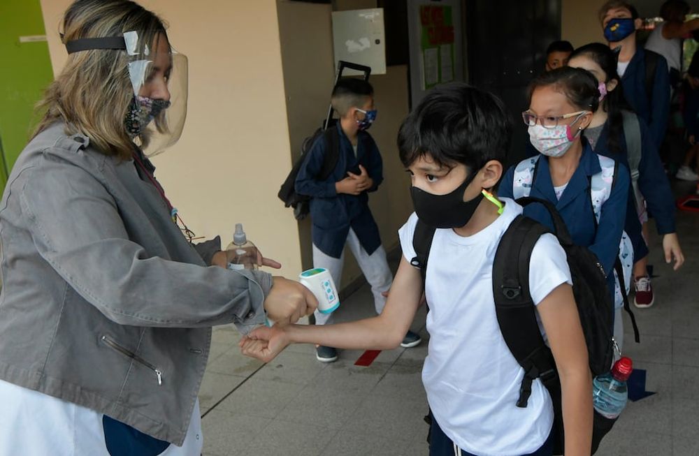 En fila. Los docentes recibieron, en las puertas de las escuelas, a sus alumnos. Antes de ingresar, les tomaron la temperatura y les rociaron alcohol en sus manos. Foto: Orlando Pelichotti / Los Andes