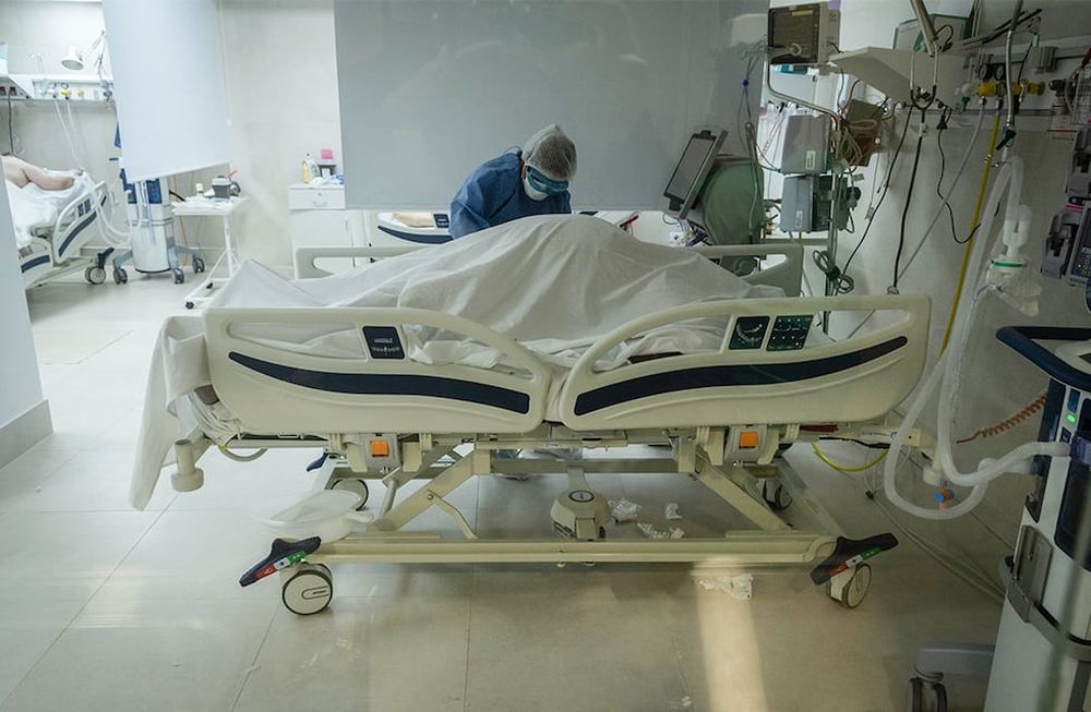 En la sala de terapia intensiva del Hospital El Carmen, la enfermera Érica Blanco cubre el cuerpo de un paciente que no pudo resistir el embate del virus. / Foto: Ignacio Blanco