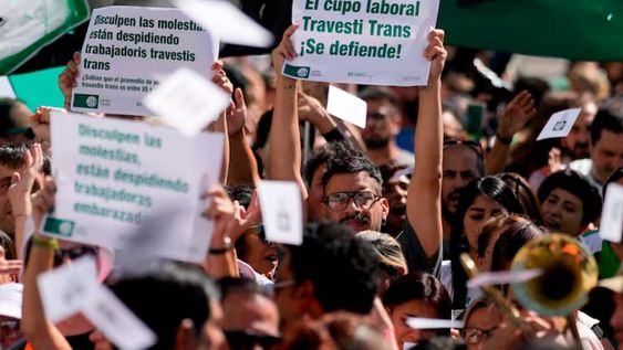 Ariel Heredia, que se identifica como no binario, muestra un cartel a favor del cupo laboral trans en una manifestación que reclama la reincorporación de empleados públicos despedidos, a las afueras del Ministerio de Economía en Buenos Aires. Foto: La Nación