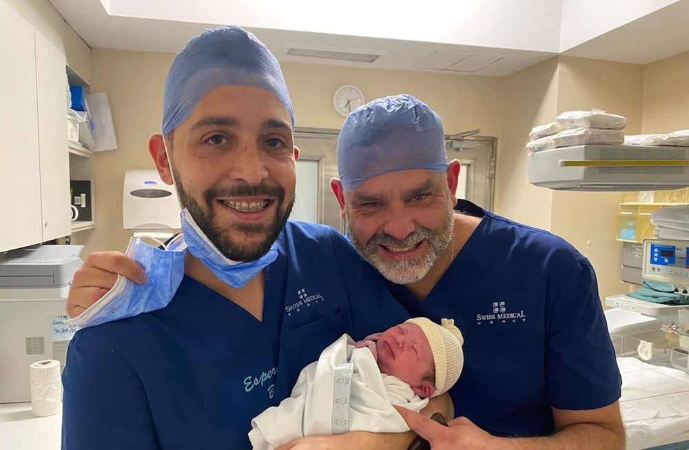 Facundo y Damián posan en brazos con Gaspar, en sus primeros minutos de vida. El bebé fue gestado a través de Mónica, quien puso su vientre para el embarazo.