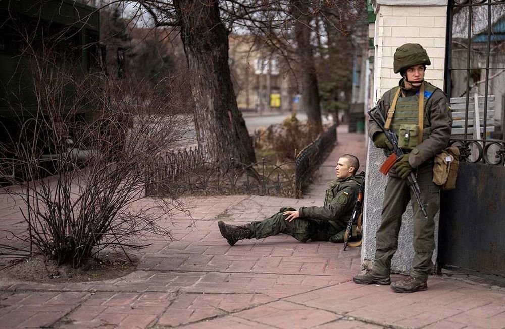 Un soldado ucraniano se sienta herido después de cruzar el fuego dentro de la ciudad de Kiev, Ucrania, el viernes 25 de febrero de 2022.AP Photo/Emilio Morenatti)