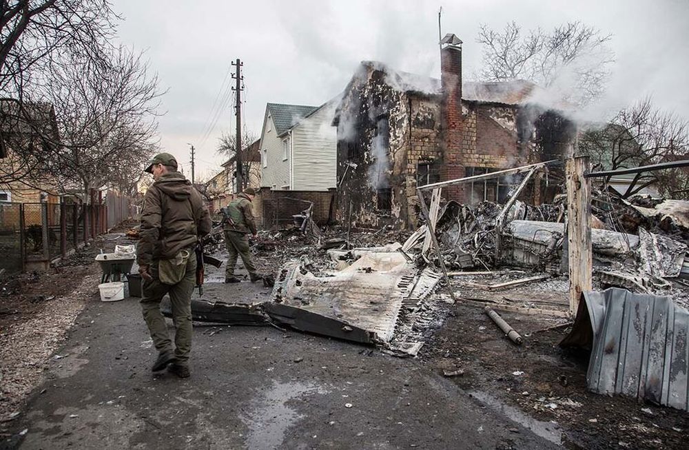 Militares ucranianos caminan frente a los fragmentos de un avión derribado visto en Kiev. (AP Photo)