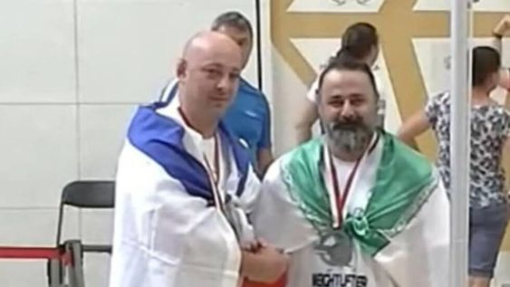 Maksim Svirsky y Mustafa Rajaei, atletas israelí e iraní respectivamente, dándose la mano luego de quedar tercero y segundo en una competencia de levantamiento de pesas en Polonia.