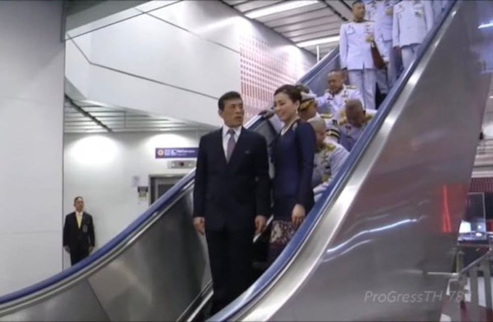 El rey de Tailandia es escoltado por un séquito de personas que deben arrodillarse en una escalera mecánica. Foto Andrew MacGregor Marshall
