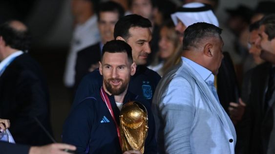 Lionel Messi, con la copa de campeón del mundo, acompañado por el DT Lionel Scaloni y por el presidente de AFA Claudio Tapia en la llegada de la selección al país. Gentileza: Clarín