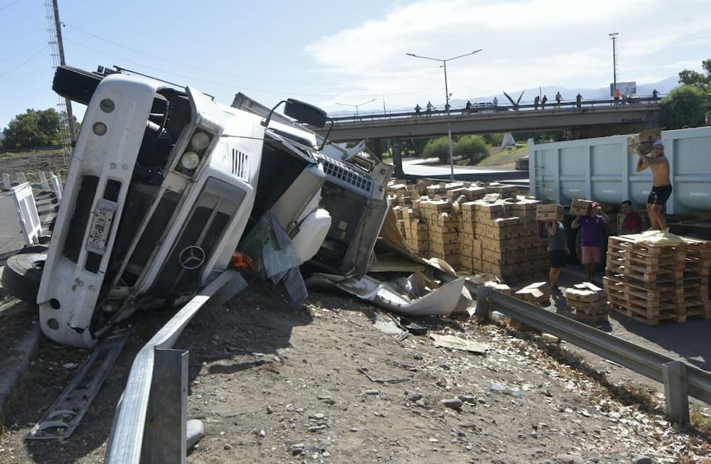 Un camión que transportaba papas congeladas volcó en el Acceso Este y la gente saqueó la mercadería. Foto: Orlando Pelichotti / Los Andes