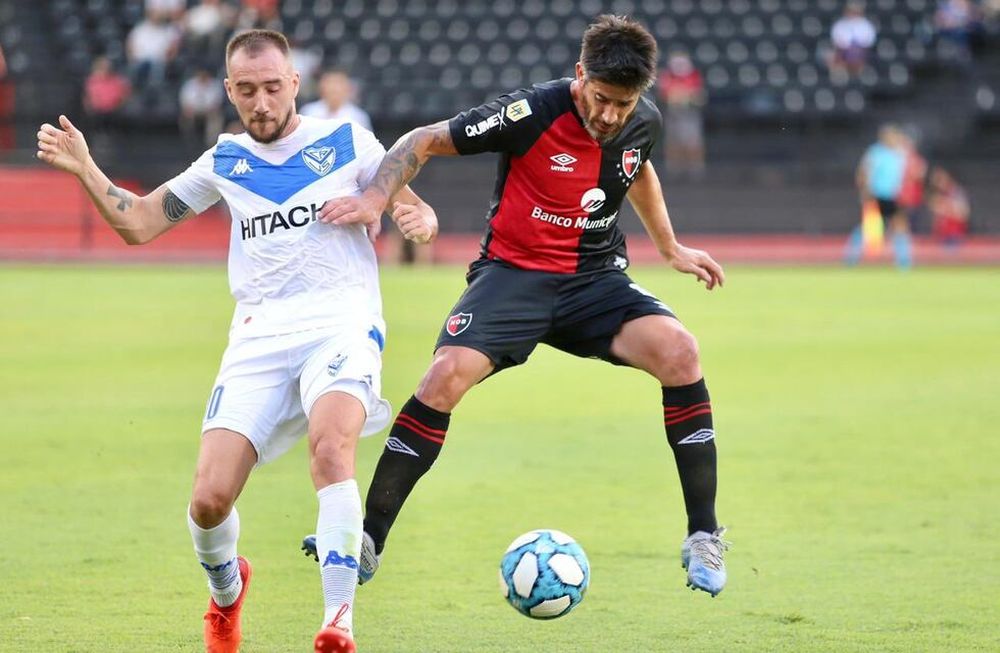 El volante de Newells Old Boys, Pablo Pérez, disputa la pelota con Federico Mancuello en el partido ante Vélez Sarsfield. / Gentileza: @canoboficial.