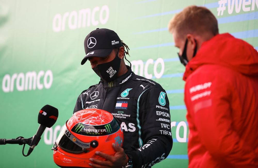 El piloto de Mercedes Lewis Hamilton recibe el casco de Michael Schumacher de parte de su hijo, Mick, luego de ganar el Gran Premio de Nürburgring en Alemania.