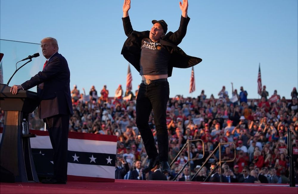 Elon Musk salta en el escenario mientras el candidato presidencial republicano y expresidente, Donald Trump, habla en un mitin de campaña en la Feria Agrícola de Butler, el sábado 5 de octubre de 2024, en Butler, Pensilvania. (AP Photo/Evan Vucci)