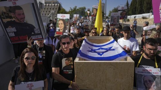 Hagit y Ruby Chen (izq) llevan un féretro vacío en simulacro de procesión fúnebre para israelíes cuyos restos están retenidos por el grupo palestino Hamás en la Franja de Gaza, cerca de la sede del Parlamento israelí, en Jerusalén, el 9 de mayo de 2024, en la previa al Día de los Caídos que recuerda a los soldados muertos en la guerra de independencia de Israel. (Foto AP/Ohad Zwigenberg)