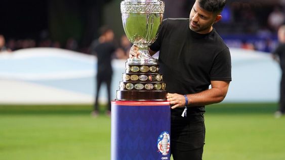 Sergio Agüero, exjugador de la selección argentina, mirando de cerca el trofeo de la Copa América el día de la inauguración del torneo. (AP)