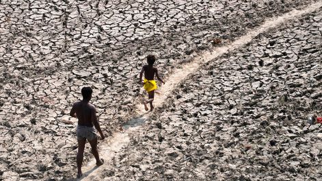 Los Andes | Un hombre y un niño caminan a través del lecho casi seco del río Yamuna luego de una ola de calor en Nueva Delhi. / Foto: AP / Manish Swarup
