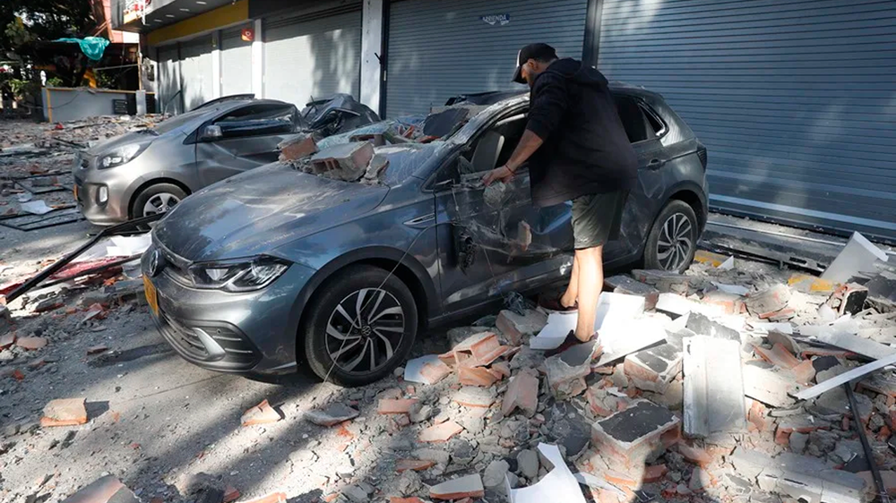 Un hombre observa un veh&iacute;culo afectado tras el terremoto en Cali (Colombia).