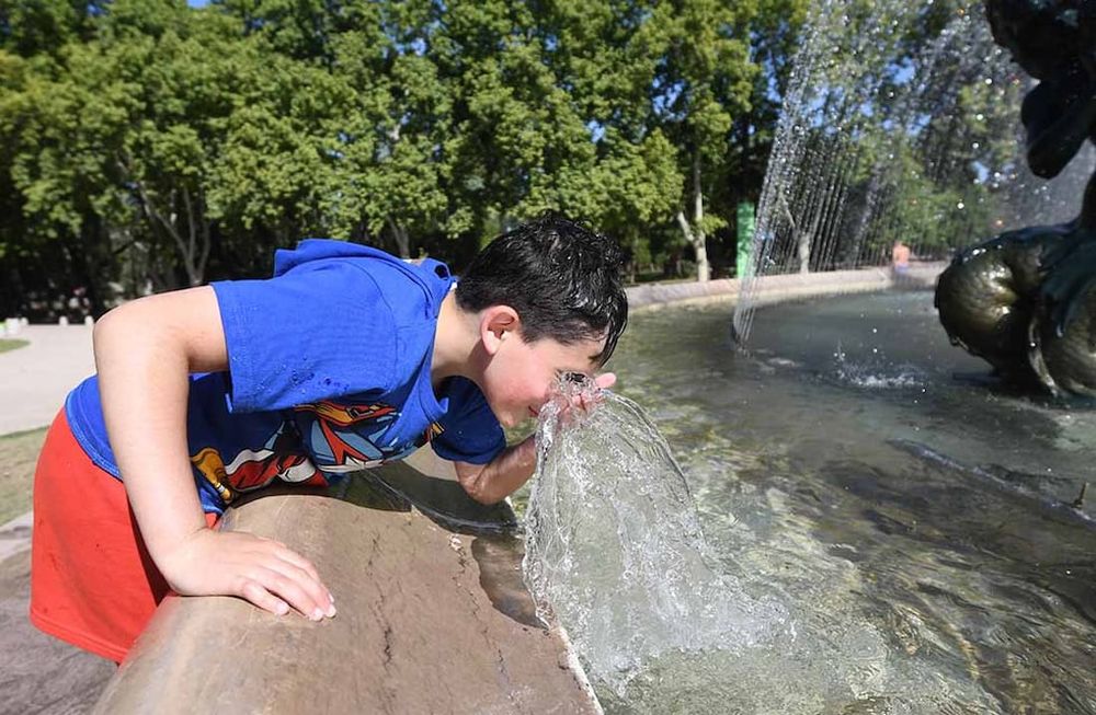 Calor en Mendoza.Se viene una semana con temperaturas mayores a 30 grados en la provincia de Mendoza.Juan Francisco junto a su papá Urbano y su hermanito Francesco se refresca en la fuente de Los Continentes en el parque General San Martín de Ciudad.