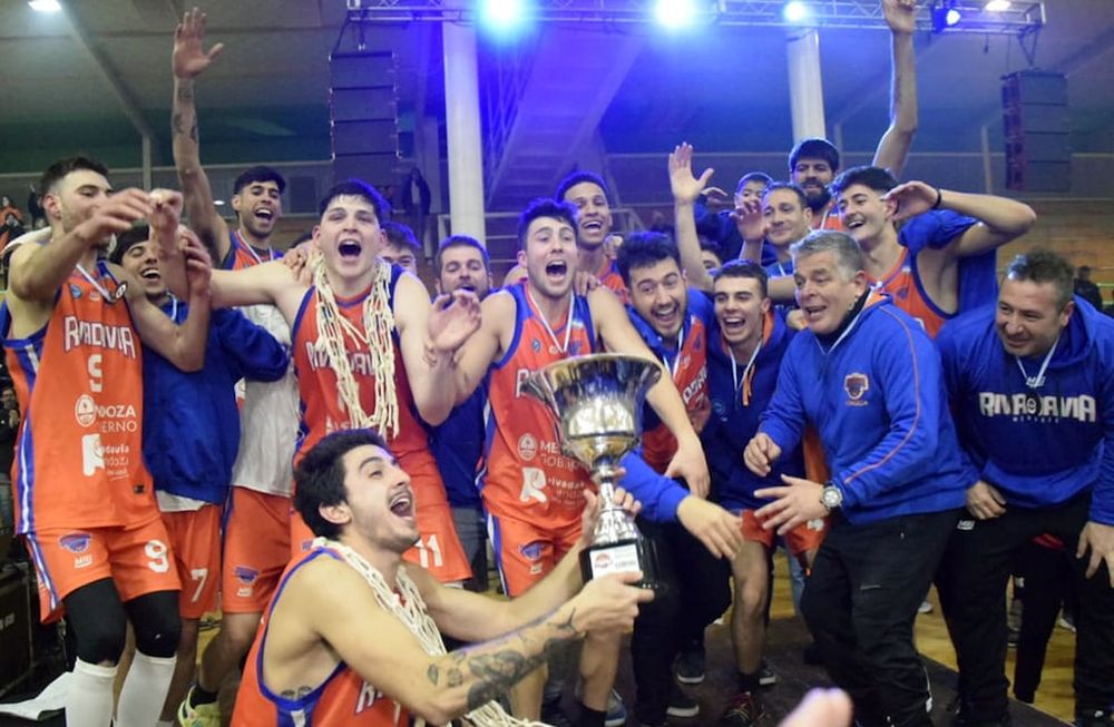 Arancibia posa con el trofeo en sus manos, mientras sus compañeros y cuerpo técnico deliran detrás.