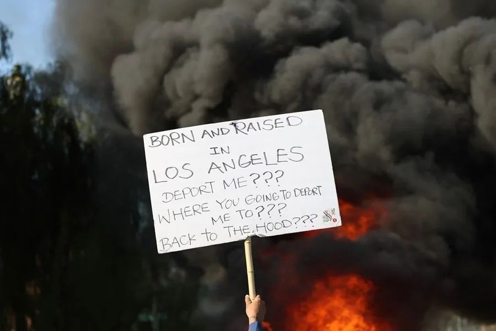 Una persona con un cartel en contra de las deportaciones en las protestas de Los Ángeles
