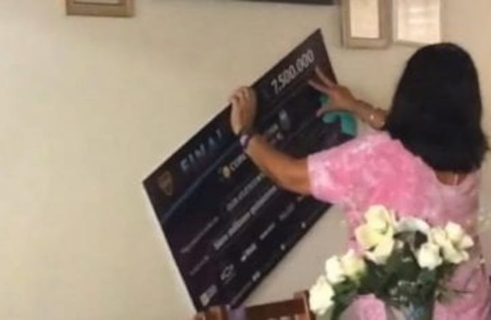 La mamá de Marcos Rojo con el cheque de la Copa Argentina en el living de su casa. / Gentileza.