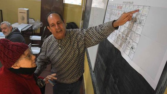 Elecciones provinciales PASO 2023 en la provincia de Mendoza.En la Escuela Rafael Obligado de Guaymallén, Los votantes ingresaban para votar en una mañana electoral tranquila pero fría.Hilda, una abuela de 85 años en el momento de emitir su voto.El Presidente de mesa le explica como votar en la nueva voletaFoto: José Gutierrez / Los Andes
