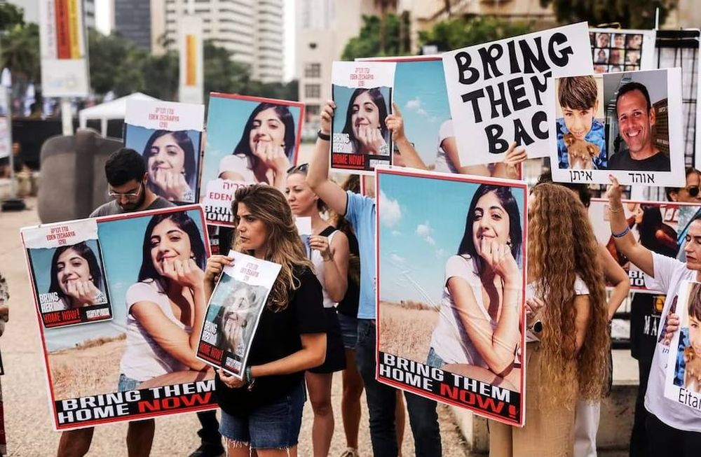 Varias personas sostienen fotos de personas desaparecidas y rehenes que se cree que han sido secuestrados por Hamas (REUTERS/Hadas Parush)
