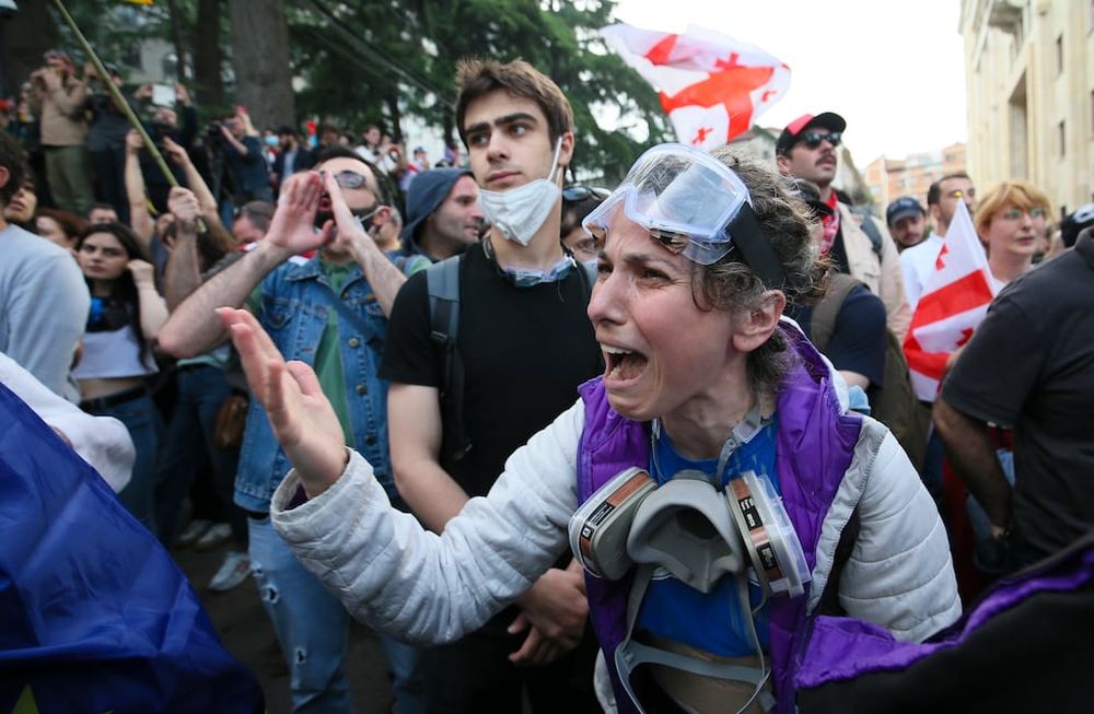 Una manifestante discute con policías durante una protesta opositora contra una ley sobre influencia extranjera ante el edificio del Parlamento en Tiflis, Georgia, el martes 28 de mayo de 2024. (AP Foto/Zurab Tsertsvadze)