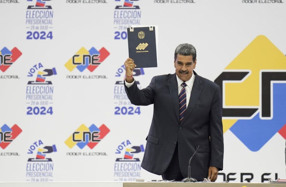 Nicolás Maduro sostiene su certificación del Consejo Nacional Electoral (CNE) que lo declara ganador de las elecciones presidenciales, en el CNE en Caracas, Venezuela, el lunes 29 de julio de 2024. (AP / Matías Delacroix)