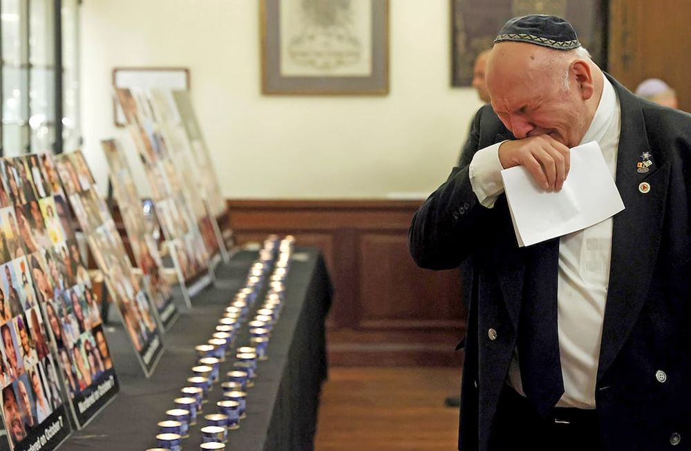 Un hombre observa carteles con imágenes de víctimas mientras asiste a una ceremonia oficial de conmemoración en la Gran Sinagoga de Bruselas. (AP)