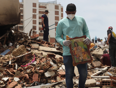 Un hombre sostiene un cuadro sobre escombros de edificaciones destruidas este martes, en La Guaira (Venezuela)