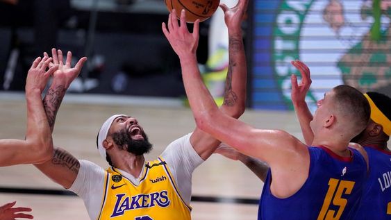El jugador de Los Angeles Lakers Anthony Davis (izquierda) y su rival de Denver Nuggets, Nikola Jokic (15), compiten por el control del balón durante el segundo medio tiempo de la final de Conferencia Oeste de la NBA.